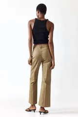 Pantalón tobillero de corte bootcut en lona de algodón, color marrón, con cintura estándar, bolsillos delanteros y pliegues marcados.