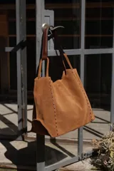 Cartera shopper amplia de gamuza color camel con costuras decorativas y asas de hombro de cuero a contratono.