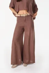 Pantalón de lino italiano con diseño estampado a rayas verticales en tonos negro y beige, de tiro medio y corte ancho.