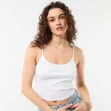 Top blanco de tirantes finos ajustables, confeccionado en tejido de canalé y diseño al cuerpo.