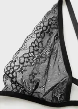 Sosten tipo triángulo confeccionado en encaje negro con diseño floral, tirantes finos y cierre de gancho posterior.