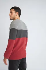 Sweater de tejido de punto con diseño color block en tonos verde, azul y gris. Presenta cuello redondo, mangas largas y corte regular.