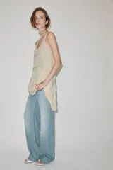 Vestido corto de viscosa color crudo, con escote redondo, manga sisa y diseño en jacquard con aplicaciones de abalorios. Presenta múltiples paneles superpuestos y bajo asimétrico.