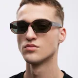 Lentes de sol unisex de forma geométrica, con armazón marrón y lentes polarizadas de color verde oscuro.