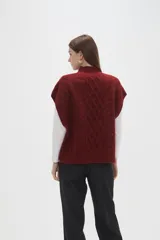 Chaleco de punto con diseño de ochos, cuello alto y corte holgado.