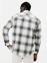 Camisa a cuadros de manga larga con dos bolsillos frontales con botón.