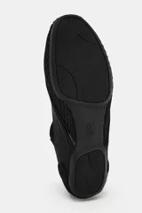 Bailarina deportiva negra, confeccionada con una combinación de malla, gamuza sintética y material elástico, con tiras cruzadas en el empeine.