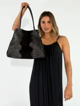 Cartera tipo tote de cuero color beige con textura gamuzada y detalles con grabado de cocodrilo en el centro y los laterales. Cuenta con doble asa de hombro.