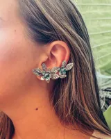 Aros trepadores plateados con diseño de hojas y flores con pequeñas piedras verdes.