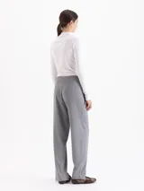Pantalón de punto liso color gris, de corte recto y silueta relajada. Presenta cintura alta con cinto integrado, bolsillos aplicados en el delantero y tajos frontales en el ruedo.