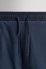 Shorts de entrenamiento azul marino con calza interior negra. Cintura elástica ajustable con cordón, bolsillos laterales con cierre y aberturas laterales en el bajo.