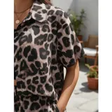 Conjunto de dos piezas compuesto por una camisa de manga corta con cuello italiano y cierre frontal de botones, y un short con cintura elástica y bolsillos laterales. Ambas prendas presentan un diseño estampado de animal print.