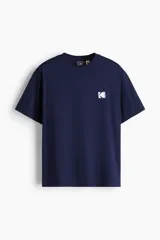 Remera de algodón de corte holgado con cuello redondo acanalado y mangas cortas. Presenta un pequeño logo estampado de Kodak en el pecho.