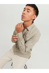 Camisa de denim color beige, con cuello clásico, cierre con botones y dos bolsillos frontales con solapa abotonada. Corte slim.