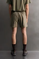 Short deportivo de entrenamiento color marrón, confeccionado en tejido técnico ligero y elástico. Cuenta con cintura elástica ajustable con cordón, bolsillos frontales, bolsillo trasero con cierre y aberturas laterales en el bajo. Incluye detalle de logo estampado en la pernera.