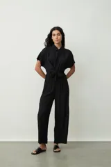 Mono largo negro de corte palazzo con camisa de mangas cortas con botones y lazo en la cintura.