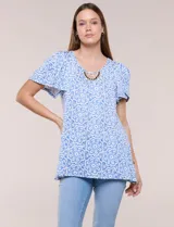 Blusa estampada en tonos de azul y blanco, con escote redondo, aplique artesanal bordado en el centro del pecho, mangas cortas tipo mariposa con volados y ruedo asimétrico.