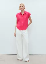 Camisa sin mangas de lyocell color fucsia, con cuello camisero y cierre frontal de botones.
