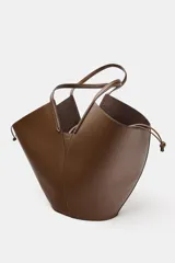 Bolso de hombro estilo capazo, color marrón, con doble asa de hombro y cuerpo con pespuntes. Presenta un cierre mediante pasador con clip metálico y una bolsa interior extraíble con cierre fruncido.
