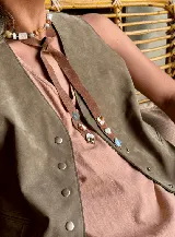 Corbatín estilo boho confeccionado en tira de cuero con piedras naturales incrustadas de diversos colores y formas.