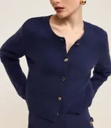 Cardigan azul marino de punto con cuello redondo, mangas largas y textura acanalada. Tiene abotonado delantero con botones mixtos.