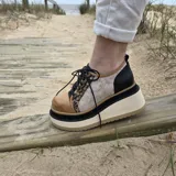 Botas cortas de cuero estilo borceguí con plataforma alta, cordones negros y diseño combinado en tonos negro, marrón y detalles animal print en los laterales.