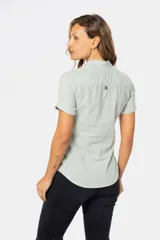 Camisa de lino de manga corta con cuello camisero, cierre frontal de medio botón con botones metálicos personalizados y dos bolsillos en el pecho.