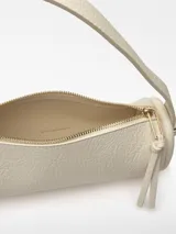 Bolso cilíndrico pequeño de textura granulada, con cierre de cremallera superior, asa de hombro fija y correa larga regulable extraíble. Presenta el logo de la marca grabado en el frente.