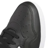 Championes de corte medio Adidas Hoops 4.0 Mid, color negro con las icónicas tres tiras laterales en blanco. Presentan un diseño de inspiración basquetbolística con empeine de cuero sintético, puntera reforzada y suela de goma blanca.