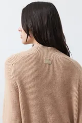 Polera de tejido de punto en color marrón oscuro, con cuello alto y diseño de silueta relajada.