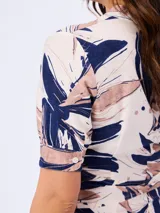 Vestido midi con estampado abstracto de hojas en tonos azul marino y beige, cuello en V con solapa, mangas cortas y lazo ajustable en la cintura.