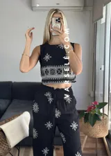 Conjunto de top sin mangas y pantalón palazzo con cintura elastizada, ambos de color crudo con estampado de flores y motivos geométricos en negro.