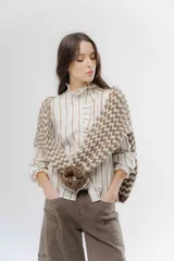 Buzo de punto grueso con diseño bicolor en patrón geométrico, de calce holgado y mangas largas.