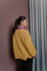 Saco tejido de punto abierto en color amarillo mostaza, con diseño de mangas amplias y corte holgado.