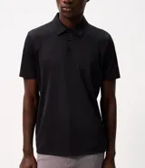 Camisa polo masculina de manga corta, confeccionada en tejido técnico de poliamida con elastano. Presenta cuello inglés con cierre de botones y diseño liso en color marrón, con tecnología de secado rápido y confort térmico.