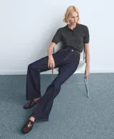 Pantalón de jean de corte recto y tiro medio, en color azul oscuro con costuras en contraste. Presenta cierre frontal con botón y bolsillos laterales y traseros.