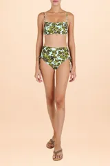 Top de bikini estilo bandeau con estampado animal print sobre fondo turquesa, decorado con incrustaciones metálicas brillantes y breteles finos.