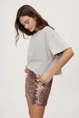 Falda corta de tiro medio con diseño de lentejuelas negras y silueta recta.