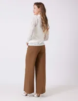 Blusa de encaje negro con cuello alto y mangas largas. Incluye musculosa interna a tono para mayor cobertura.