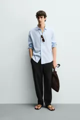 Pantalón de corte regular fit confeccionado en tejido mezcla de algodón, con cintura elástica ajustable mediante cordón, bolsillos laterales y bolsillos traseros de vivo.