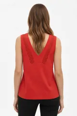 Musculosa de algodón color rojo, de bretel ancho, con escote en V y detalles de encaje aplicado alrededor del cuello.