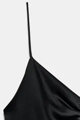 Vestido corto negro, con escote pico drapeado y tirantes finos.