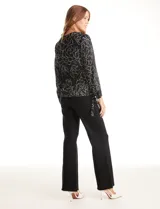 Blusa de gasa estampada con flores blancas sobre fondo negro, marca Zac & Rachel. Presenta cuello a la base, escote en V con abertura de botones y mangas 3/4 amplias. Los laterales tienen lazo.