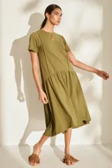 Vestido midi color crudo de manga corta, con corte en la cintura y falda holgada con volados y detalle de pequeño bordado de hongo en el pecho.