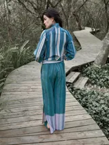 Pantalón de lino con estampado a rayas verticales en tonos celeste, verde, marrón y blanco.