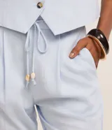 Pantalón fluido Marfinno modelo pijama, color blanco, confeccionado en viscolino. Cuenta con cintura elástica en la espalda, lazo de ajuste, pliegues frontales y bolsillos laterales.