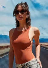 Body color marrón oscuro, confeccionado en microfibra, con escote delantero y trasero cerrado, cuerpo embolsado y gancho corsetero regulable en la entrepierna.