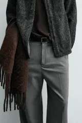 Pantalón de corte wide fit confeccionado en tejido fluido con viscosa. Presenta bolsillos delanteros, bolsillos traseros de vivo, cierre frontal con cremallera y botón, y trabillas para cinturón.