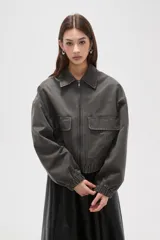 Campera de estilo utilitario en color gris oscuro con efecto lavado, confeccionada en poliéster. Presenta cuello camisero, cierre frontal con cremallera, bolsillos frontales con solapa y puños elásticos.
