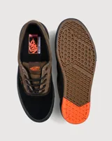 Championes Vans modelo Skate Era Wafflecup, con diseño bicolor en negro y marrón. Presentan una silueta clásica de skate con suela WaffleCup que combina durabilidad y flexibilidad, cordones negros y detalles en color naranja en la lengüeta, plantilla y suela.